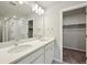 Bathroom featuring a double vanity with white countertops, dual sinks and a walk-in shower at 7360 Watercress Dr, Littleton, CO 80125