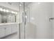 A well lit bathroom with a double sink vanity and glass enclosed shower with white tile surround at 7360 Watercress Dr, Littleton, CO 80125