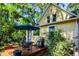 A well-appointed backyard deck features an outdoor dining set and grill, surrounded by lush landscaping and trees at 310 Judson St, Longmont, CO 80501