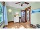 Green bedroom featuring a ceiling fan, wood floors, wood trim, and a view of bathroom at 310 Judson St, Longmont, CO 80501