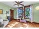 Light-filled bedroom featuring a ceiling fan, wood floors, wood trim, and windows at 310 Judson St, Longmont, CO 80501