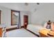 This bedroom has hardwood floors and a red bookcase by the window with wood trim at 310 Judson St, Longmont, CO 80501