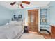 Light blue bedroom features a ceiling fan, vintage wood door and built-in shelving at 310 Judson St, Longmont, CO 80501