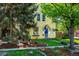 Charming yellow two-story home with mature landscaping and a well-maintained lawn at 310 Judson St, Longmont, CO 80501