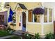 Close-up of the charming yellow home's front entrance, featuring a hanging flower basket at 310 Judson St, Longmont, CO 80501