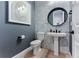 Stylish powder room with mosaic tile accent wall, sleek fixtures, and a modern round mirror at 3394 Backdrop Ct, Castle Rock, CO 80108