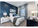 Cozy bedroom with a navy accent wall, stylish decor, and a bright window view at 3394 Backdrop Ct, Castle Rock, CO 80108