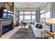 Sunlit living room with a fireplace, plush sofa, and expansive windows offering neighborhood views at 3394 Backdrop Ct, Castle Rock, CO 80108