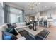 Open-concept living room with a large sectional sofa, modern lighting, and adjacent kitchen area at 3394 Backdrop Ct, Castle Rock, CO 80108