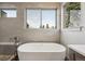 Soaking tub with modern faucet set below large picture windows and light gray tile surround at 350 15Th St, Boulder, CO 80302