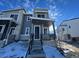 Modern two-story home with gray siding and stone accents, welcoming front porch, and steps leading to the entrance at 22841 E Stanford Ln # A, Aurora, CO 80015