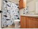 Cozy bathroom featuring playful shark-themed shower curtain, wooden vanity and ample lighting at 371 Smith Cir, Erie, CO 80516