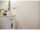 Modern half-bath with black hardware, white vanity, stylish mirror, and sleek design elements at 371 Smith Cir, Erie, CO 80516