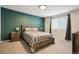 Tranquil bedroom with a soothing green accent wall, natural wood furnishings, and a carpeted floor at 371 Smith Cir, Erie, CO 80516