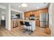 Open kitchen with stainless steel appliances, wood cabinets, an island and stylish bar stools at 371 Smith Cir, Erie, CO 80516
