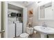 Cozy bathroom featuring in-unit washer and dryer and pedestal sink, blending functionality with a welcoming aesthetic at 6650 E Arizona Ave # 154, Denver, CO 80224