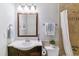 Well-lit bathroom featuring a decorative mirror, wood vanity and tiled shower at 6650 E Arizona Ave # 154, Denver, CO 80224