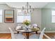 Dining room featuring hardwood floors, chandelier, and a modern table set with seating for four guests at 6650 E Arizona Ave # 154, Denver, CO 80224