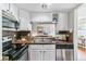 Well-designed kitchen featuring stainless appliances, white cabinets and sink with view into living room at 6650 E Arizona Ave # 154, Denver, CO 80224