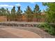 Backyard featuring a rock wall, gravel, and mature trees at 24269 E Arapahoe Pl, Aurora, CO 80016