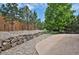 Backyard with rock features, rock wall, and mature trees at 24269 E Arapahoe Pl, Aurora, CO 80016