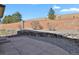 Home backyard with a gravel foundation, small shrubs, and a stone wall feature at 24269 E Arapahoe Pl, Aurora, CO 80016