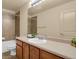Bathroom featuring wood vanity, mirror, tub and shower combo with neutral tile, and ample lighting at 24269 E Arapahoe Pl, Aurora, CO 80016