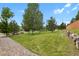 Beautifully landscaped front yard featuring a lush green lawn and mature trees at 24269 E Arapahoe Pl, Aurora, CO 80016