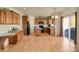 Open kitchen featuring wood cabinets, island, black appliances, and sliding glass doors to the exterior at 24269 E Arapahoe Pl, Aurora, CO 80016