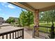 View from the porch of this home with brick supports and a stained wood railing, overlooking the front lawn at 24269 E Arapahoe Pl, Aurora, CO 80016