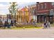 Street-level view of the Southlands sign with retail shops and people walking by at 24269 E Arapahoe Pl, Aurora, CO 80016