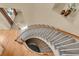 An upper-level view of a curved staircase with carpeted steps and white railings, showcasing the home's design at 24269 E Arapahoe Pl, Aurora, CO 80016