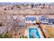 An aerial view of a neighborhood, showcasing a home with solar panels and a backyard pool at 6410 S Kendall St, Littleton, CO 80123