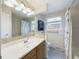 Bright bathroom with a large mirror, vanity, and tiled shower at 6410 S Kendall St, Littleton, CO 80123