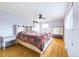 Bright bedroom with wood floors, ceiling fan, and colorful bedding at 6410 S Kendall St, Littleton, CO 80123