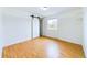 Sunlit bedroom featuring laminate wood flooring and a sliding barn door closet at 6410 S Kendall St, Littleton, CO 80123