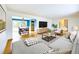 Open-concept living room featuring hardwood floors, a stylish sofa, and a dining area at 6410 S Kendall St, Littleton, CO 80123