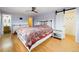 Cozy bedroom features a ceiling fan, stylish barn door, and wood laminate flooring at 6410 S Kendall St, Littleton, CO 80123