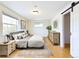 Staged Main bedroom features an accent rug, furnishings, and barn door to bathroom at 6410 S Kendall St, Littleton, CO 80123