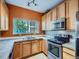 Modern kitchen featuring stainless steel appliances, orange walls and a window to the outside at 3230 Boulder Cir # 101, Broomfield, CO 80023