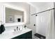 Modern bathroom featuring a sleek vanity, backlit mirror, and walk-in shower with stylish black and white tile accents at 5326 Lowell Blvd, Denver, CO 80221