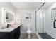 Modern bathroom with a sleek vanity, illuminated mirror, and a glass-enclosed shower with stylish tile work at 5326 Lowell Blvd, Denver, CO 80221