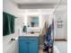 Renovated bathroom featuring a blue vanity, shower with patterned curtain, and lighted mirror at 5326 Lowell Blvd, Denver, CO 80221