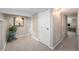 Hallway featuring neutral walls, plush gray carpeting, and modern artwork leading to an inviting living space at 5326 Lowell Blvd, Denver, CO 80221