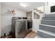 Functional laundry room with modern washer and dryer, shelving for storage, and convenient access to the basement stairs at 5326 Lowell Blvd, Denver, CO 80221