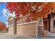 Spacious three car garage with stone accents, next to the covered front porch and red front door at 15003 W 63Rd Ave, Arvada, CO 80403
