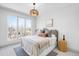 Bright bedroom featuring large windows, neutral decor, and stylish modern lighting at 556 Monroe St, Denver, CO 80206