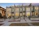 Modern townhomes with a stone facade, large windows, and well-maintained landscaping at 556 Monroe St, Denver, CO 80206