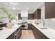 Spacious kitchen with stainless steel appliances, a marble backsplash, dark cabinetry, and a kitchen island at 556 Monroe St, Denver, CO 80206