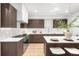 Modern kitchen featuring dark wood cabinets, white countertops, mosaic backsplash, and stainless steel appliances at 556 Monroe St, Denver, CO 80206